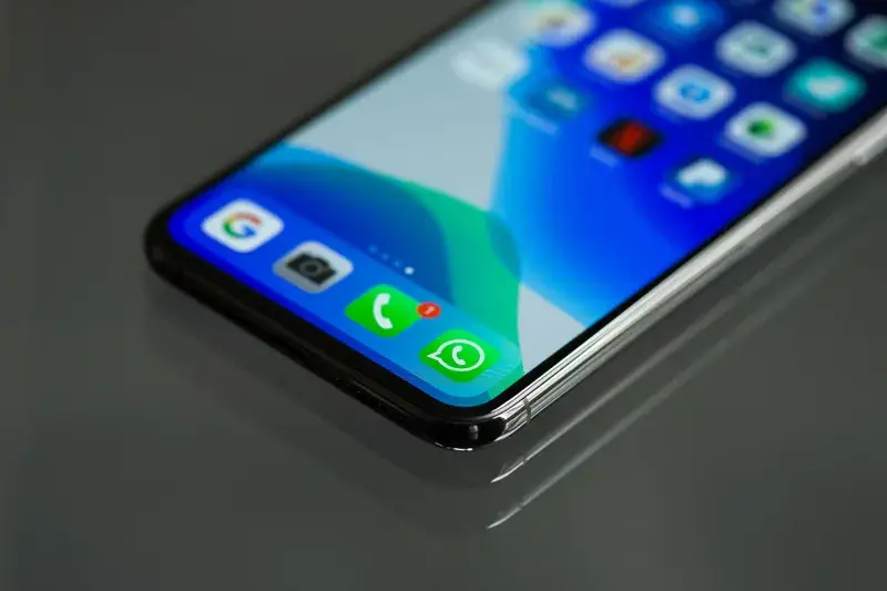 Primer plano de la pantalla de un smartphone mostrando varios iconos de aplicaciones, incluido WhatsApp.