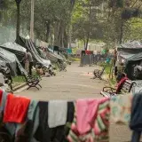 People camping in an urban park with tents and laundry in Bogotà, Colombia.