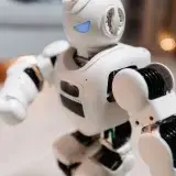 Close-up of a futuristic toy robot with blue eyes, showcasing modern technology indoors.