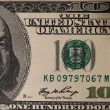 Detailed close-up image of a US one hundred dollar bill showing Benjamin Franklin.