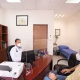 Doctor and patient with masks in medical clinic, emphasizing healthcare safety.