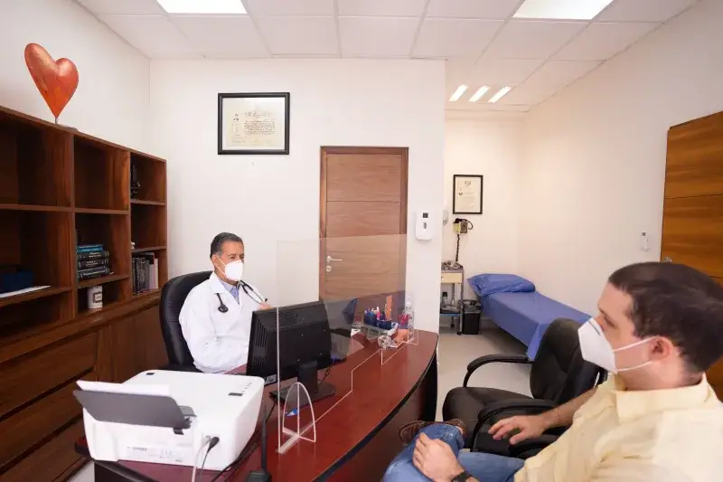 Doctor and patient with masks in medical clinic, emphasizing healthcare safety.