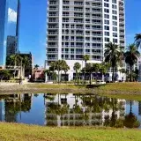 A vibrant urban scene in Sarasota, Florida, featuring buildings and a reflecting pond.