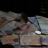 A collection of various international banknotes and coins scattered on a table.