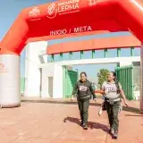 Two women cross finish line at marathon in Santa María Atarasquillo, Mexico.
