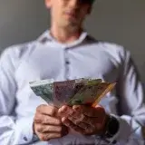 Man holding Argentine Peso banknotes in Buenos Aires, Argentina, illustrating currency concept.