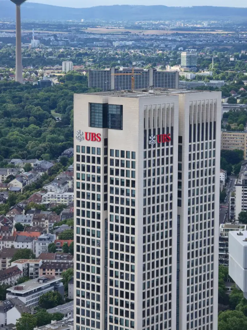 Unavista aérea panorámica que muestra la torre UBS en medio de un horizonte urbano bullicioso.