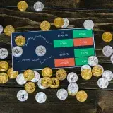 Bitcoin coins scattered around a stock chart on a dark wooden table, symbolizing cryptocurrency investment.