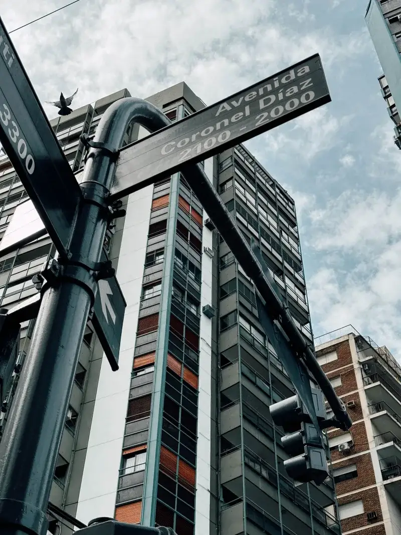 Low angle shot of Avenida Coronel Diaz street sign amidst city architecture in Buenos Aires.