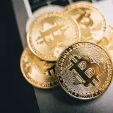 Close-up of golden Bitcoin coins on a laptop keyboard, symbolizing cryptocurrency investment.