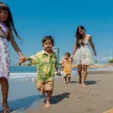 A joyful family plays on a sunny beach, capturing moments of happiness and togetherness.
