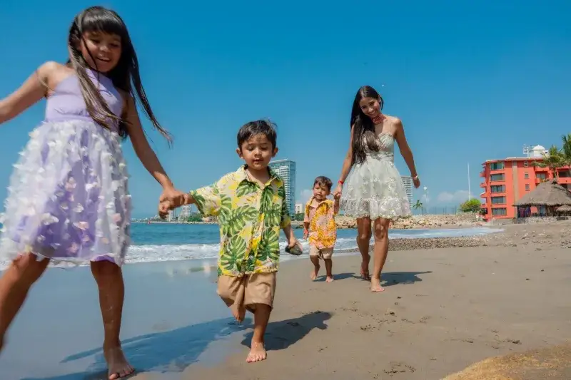 A joyful family plays on a sunny beach, capturing moments of happiness and togetherness.