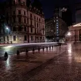 A rainy night view of historic buildings and wet streets in Buenos Aires, Argentina.