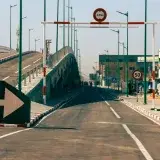 A cityscape featuring a modern bridge, clear road markings, and traffic signs, indicative of urban infrastructure.