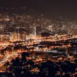 A vibrant night view of Medellin, Colombia with illuminated buildings and city lights.