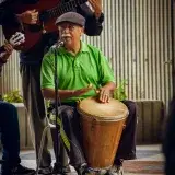 Musicians perform with drum and guitar in Venezuela, showcasing Latin rhythms and energy.