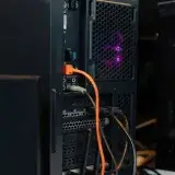 Close-up of a desktop computer tower with connected cables and internal lighting.