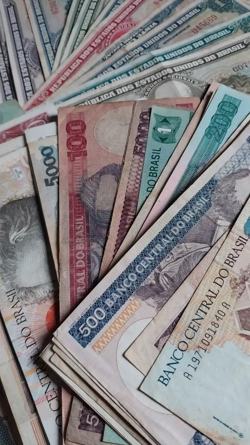 Close-up of assorted vintage Brazilian currency notes displayed in a scattered arrangement.