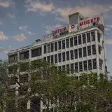Historic building in Havana, Cuba with iconic Patria o Muerte sign against a blue sky.