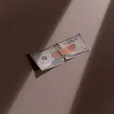 A torn dollar bill patched with a bandage, symbolizing financial recovery.