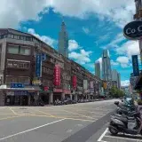 A bustling urban street scene with Taipei 101 and local shops in Taipei, Taiwan.