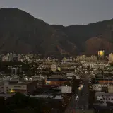 Una vista aérea de Caracas, Venezuela, que muestra el paisaje urbano con montañas al atardecer.