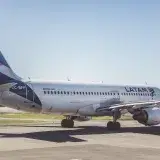 A LATAM Airlines Airbus A320 preparing for takeoff on a sunny airport runway.