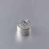 Close-up of silver Bitcoin coins stacked on a gray surface, showcasing cryptocurrency technology.