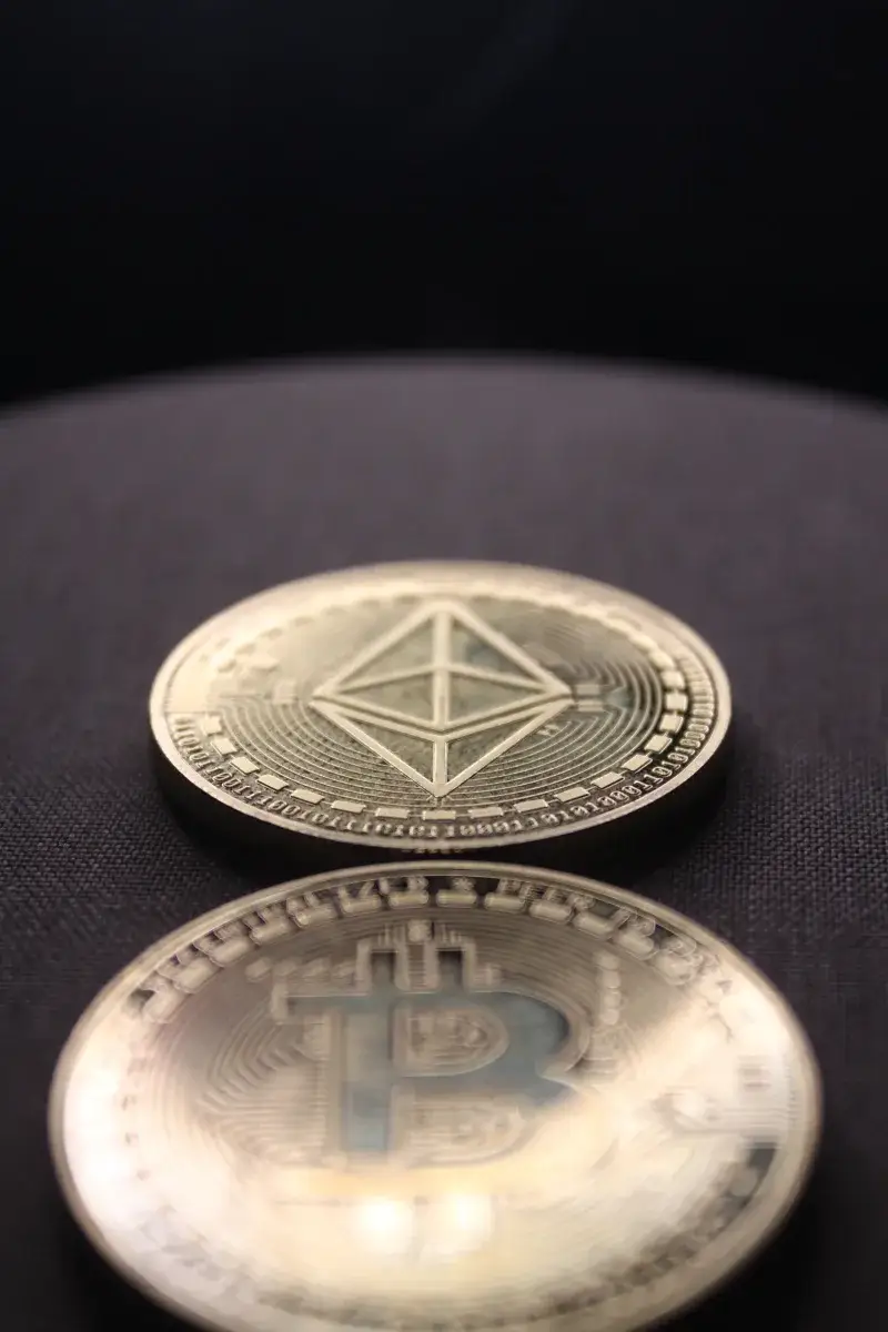 Detailed shot of Bitcoin and Ethereum coins on a dark surface.