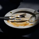 fork and knife resting on dirty empty plate
