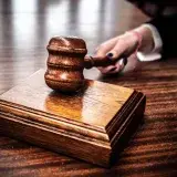 Close-up of a wooden gavel on a judge's desk, symbolizing justice.