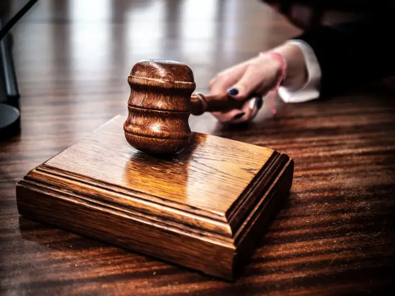 Close-up of a wooden gavel on a judge's desk, symbolizing justice.