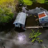 Aerial view of palafitos amidst flooded waters in Amazonas, Brazil, showcasing rural life.