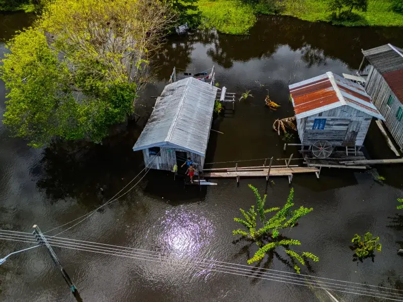 Aerial view of palafitos amidst flooded waters in Amazonas, Brazil, showcasing rural life.