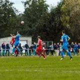 Players in blue and red compete intensely on a football field in France, capturing the spirit of the game.