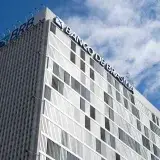 High-rise view of Banco de Brasília against a bright blue sky in Distrito Federal, Brazil.