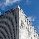 High-rise Banco de Brasília building with clear sky, capturing modern architecture against a vibrant blue background.