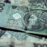 Detailed close-up of Polish zloty banknotes focusing on 100 PLN, highlighting intricate currency design.