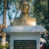 Bronze statue of Lázaro Cárdenas in a sunny Huauchinango park, capturing historical homage.
