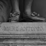 Detailed black and white close-up of a sculpture's base featuring Marc Antonio text.