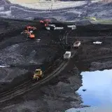 Aerial photograph showcasing machinery working in a vast open-pit mining site.