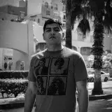 Monochrome portrait of a man standing in an urban setting in Cabo San Lucas, Mexico.
