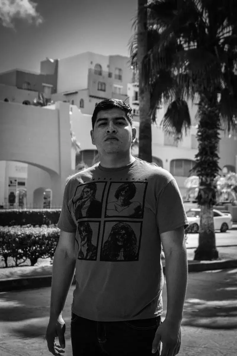 Monochrome portrait of a man standing in an urban setting in Cabo San Lucas, Mexico.
