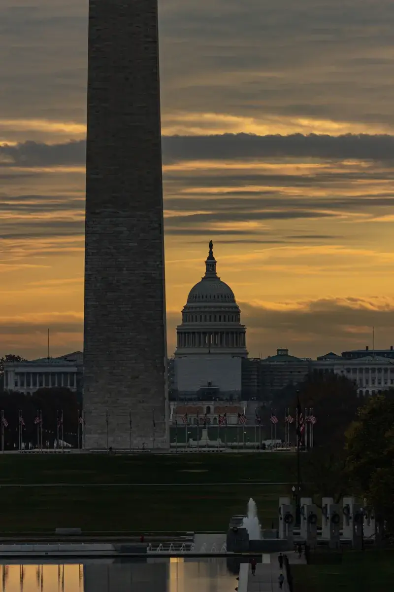 Washington D.C. skyline featuring the Washington Monument and US Capitol at sunset.