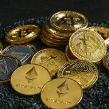 A group of gold cryptocurrency coins on top of black stones