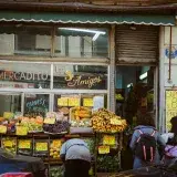 Street view of a local market 'Los Tres Amigos' in Buenos Aires with people shopping for fresh produce.