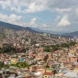 Aerial view of Medellín, Colombia's urban landscape with rolling hills and dense buildings.