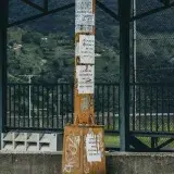 Graffiti-covered orange pole with posters in a townscape of Mérida, Venezuela.