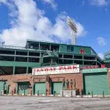Iconic Fenway Park entrance on a clear day in Boston, showcasing historic architecture and vibrant atmosphere.
