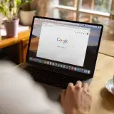 Man uses Apple MacBook in a cafe or restaurant. He is searching Google website and drinking black coffee. Free editable PSD here: https://firmbee.com/unsplashscreen4